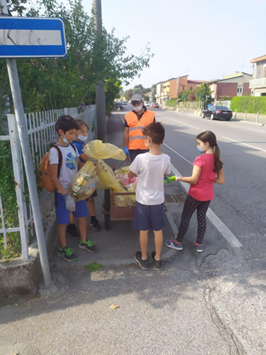 bambini che raccolgono rifiuti